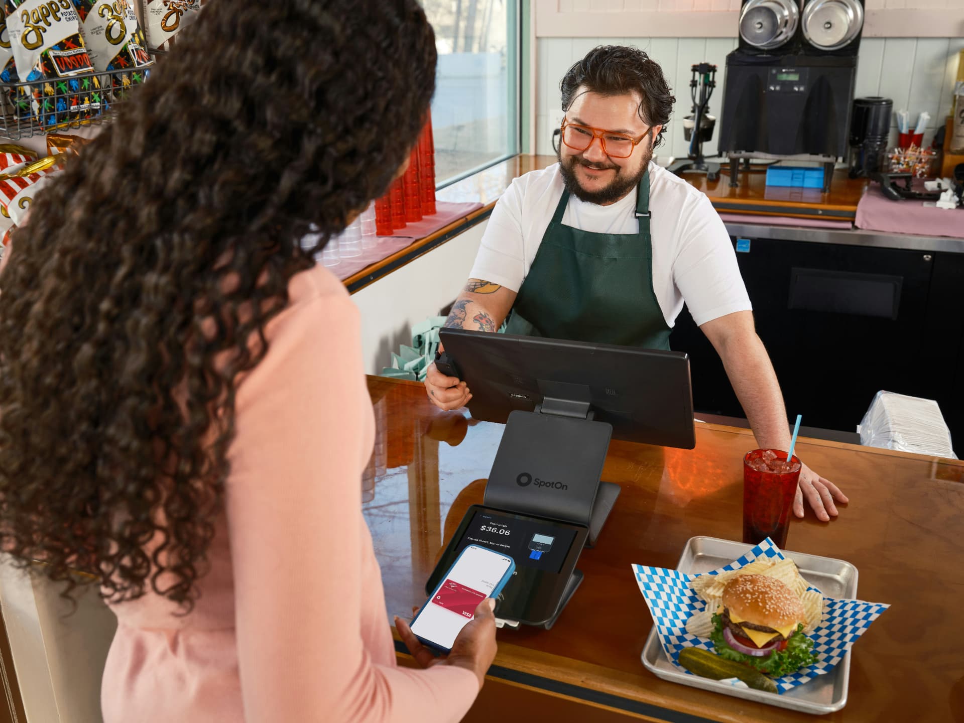 Smiling cashier serving a guest at a fast casual counter
