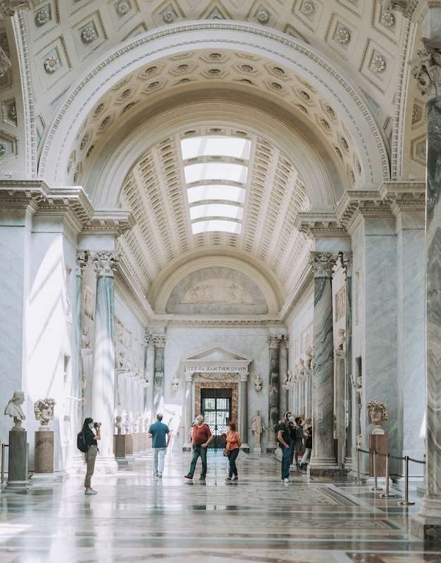 Visitors walking through a grand museum hall